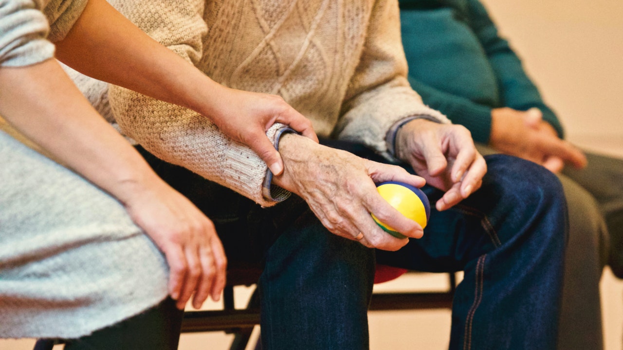 closeup of elderly hands holding a stress ball